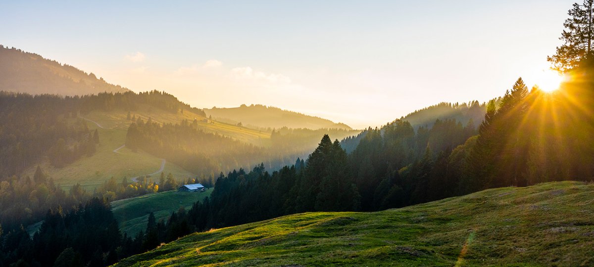 Sonnenstrahlen hinter Oberstaufens Bergen
