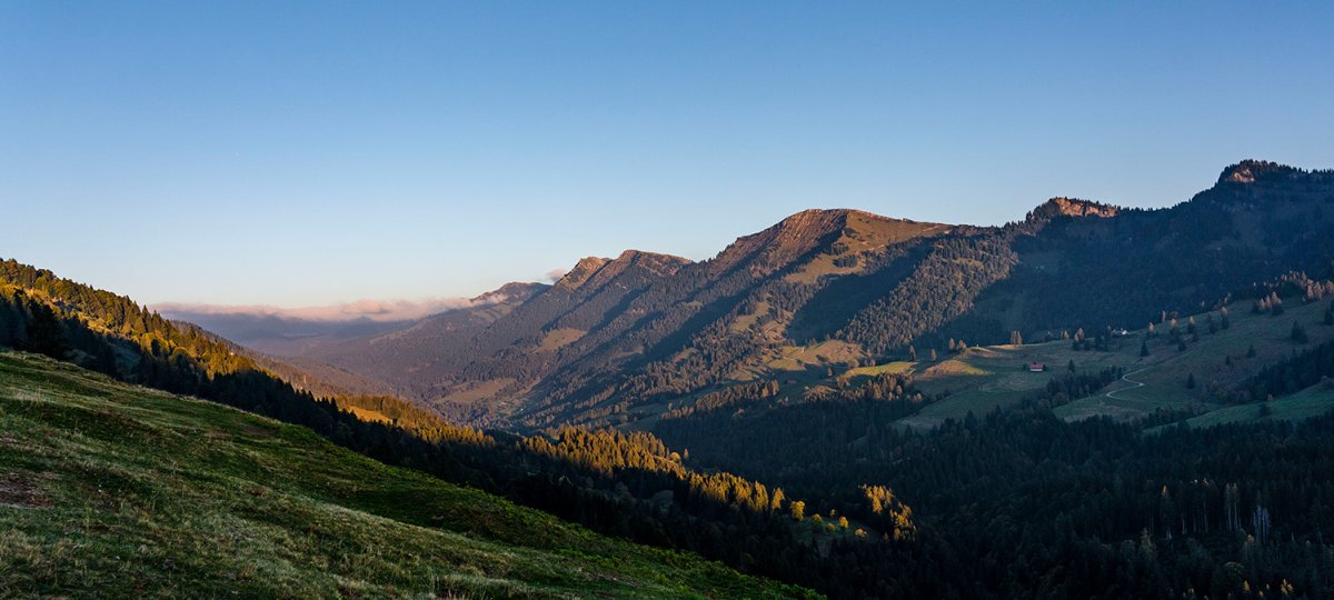 Wiesen und Berge in der Morgensonne