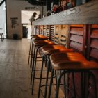 Mach es dir auf unseren stylischen Barhockern an der Bar gemütlich.