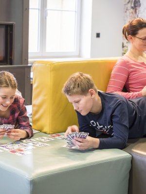 Gemütliches Karten spielen am Kamin im Wohnzimmer des Oberstdorf Hostels.