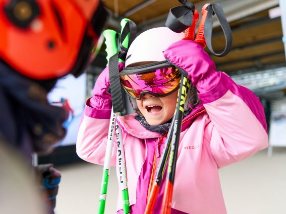 Kind setzt Skibrille auf