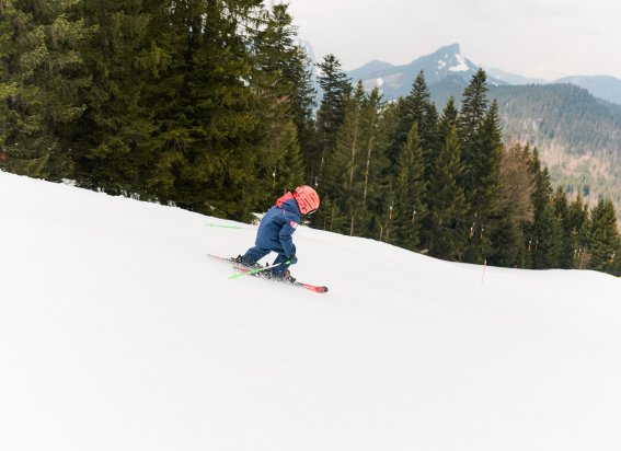 Junge carvt die Piste hinunter