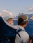 Gruppen von Menschen wandern in den Bergen während des Tages. Die Landschaft zeigt hohe Berge und blaue Himmel.
