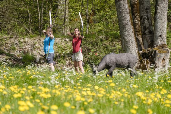 Zwei Personen beim Bogenschießen im Wald bei Bolsterlang. Zwei Personen üben das Bogenschießen auf einem naturbelassenen Parcours im Wald.