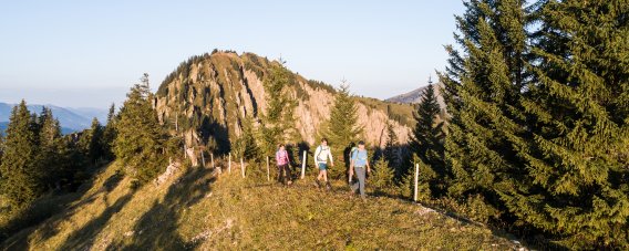 Eine Wandergruppe folgt einem aussichtsreichen Bergweg bei Balderschwang. Felsige Gipfel und alpine Wiesen prägen die abwechslungsreiche Route.