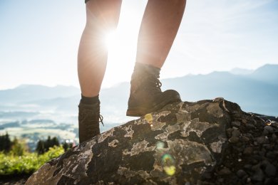 Ein Wanderer steht auf einem felsigen Aussichtspunkt über dem Tal. Der weite Blick macht die Tour rund um Bolsterlang zu einem besonderen Bergerlebnis.