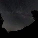 Milchstraße über einem dunklen Bergtal am Riedbergpass im Allgäu Über einem dunklen Bergtal zeigt sich ein weitläufiger Sternenhimmel mit den feinen Strukturen der Milchstraße. Tannen und Berghänge rahmen die Aufnahme ein und unterstreichen die abgeschiedene Lage am Riedbergpass.