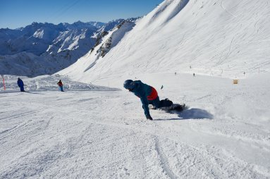 Mit dem Snowboard die Piste runterheizen