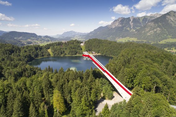 Entdecke die Skiflugschanze in Oberstdorf im Sommer! Genießen die beeindruckende Architektur und erlebe den Nervenkitzel der Skisprunggeschichte hautnah. Ein Muss für alle Sportbegeisterten und Panorama-Liebhaber – erleben Sie die majestätische Schanze mit Blick auf die Allgäuer Alpen und den Freibergsee!