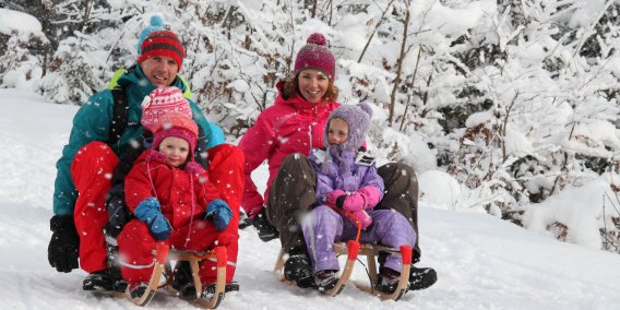 Auf die Plätze, fertig, los! Auch wenn es beim Schlittenrennen einen schnelleren gibt, beide haben etwas gewonnen: unvergesslich spaßige Momente im Schnee.