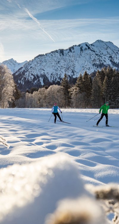 Das Alpenpanorama beim Langlaufen im Allgäu genießen. Dank der wunderschönen Winterlandschaft gilt das Allgäu als das beliebteste Wintersportgebiet.