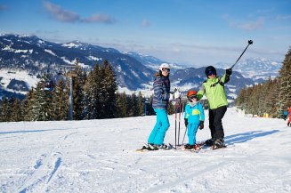 Familienurlaub im Winter richtig gestalten. Abwechslungsreiche Aktivitäten, wie Skifahren und Schlittenfahren bieten viel Spaß für die ganze Familie.