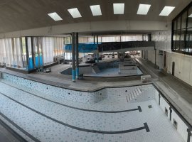 Blick in die Badehalle mit 25m-Becken und Erlebnisbecken während der Bauphase von oben.