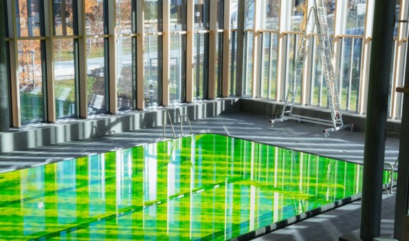 Das Bild zeigt das Sportbecken in der Therme das grün eingefärbt ist.
