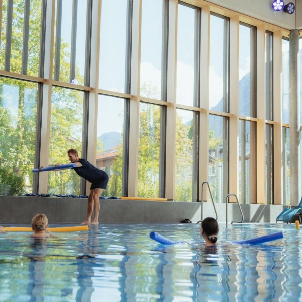 Aqua Gymnastik Einige Personen stehen mit jeweils einer Schwimmnudelim Wasser und machen bei dem kostenlosen Mitmachangebot Aquagymnastik mit. Gemeinsam mit der Trainerin sieht das nach viel Spaß aus.