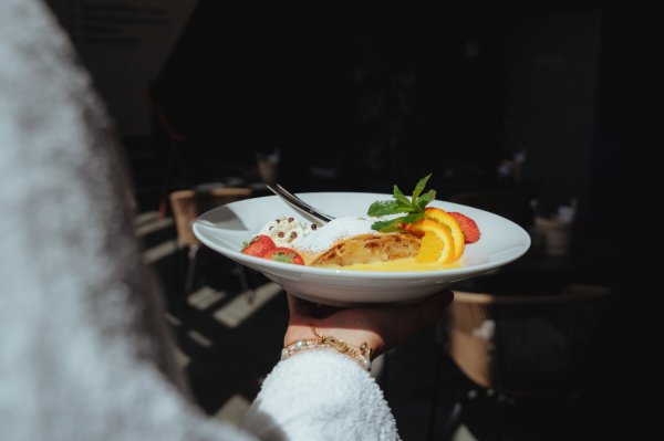 Apfelstrudel mit Vanillesoße Zu sehen ist ein Teller mit einem frisch zubereitetem Apfelstrudel. Geschmückt wurde er mit ein paar Orangen, Erdbeeren und etwas Minze. Der Puderzucker durfte natürlich auch nicht fehlen. Eine perfekte Nachspeise