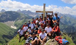 Die Bergwacht Oberstdorf ist zusammen auf dem Gipfel der Höfats und feiert das neue Gipfelkreuz.