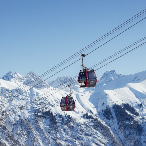 Seilbahnen fahren durch die hochgelegenen Alpen im winterlichen Schnee und bieten einen atemberaubenden Blick auf die Berge.