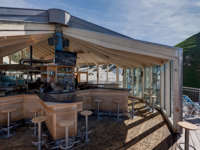 In dieser modernen Bergbar genießen Gäste die Aussicht auf die grünen Hügel. Das Holzdesign sorgt für eine warme Atmosphäre.