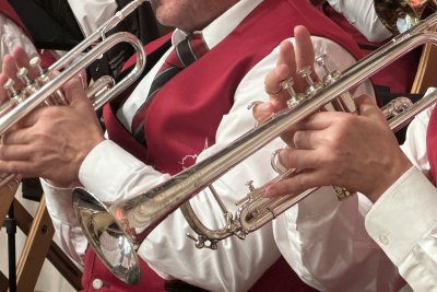 MK Sipplinger Die Musiker spielen begeistert Trompete in festlicher Kleidung während eines Konzerts in einer Halle.