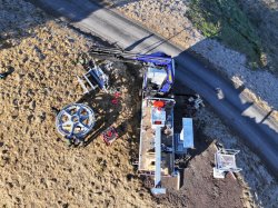 Bau Bergstation Höllwies Okt'25 Eine große Maschine arbeitet an einem Projekt neben einer Straße. Es ist Tag und der Boden ist trocken.