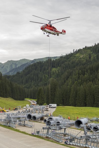 Bodenmannschaft beim anhängen einer Rollenbatterie am Hubschrauber
