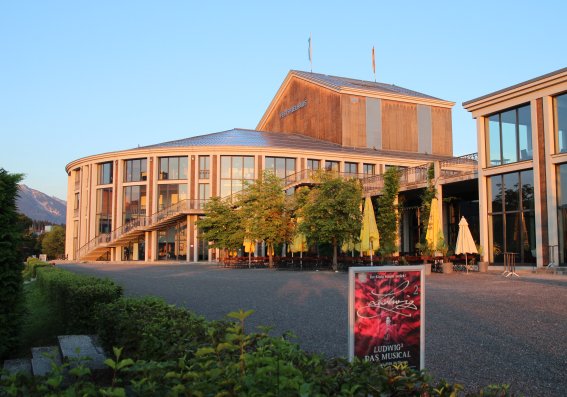 Festspielhaus Füssen im Sommer mit Ludwig2 Plakat im Vordergrund