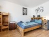 Ein Zimmer mit einem Holzbett und Regalen