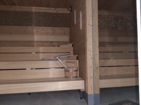 Blick in die Kräutersauna (links mit Heuwand) und in das Sanarium (rechts mit Holzscheitel-Optik)
