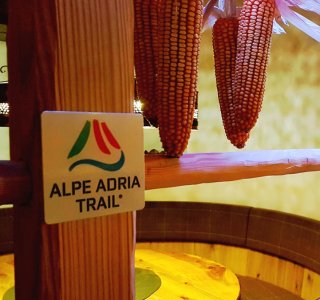 Bauernstube mit Alpe-Adria-Trail Hinweis
