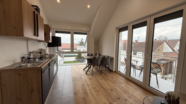 Diese Küche hat große Fenster und einen Blick auf die Straßen. Der Raum ist hell und hat moderne Möbel.
