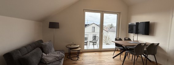 Hier ist ein Wohnraum in einem Haus. Es gibt ein Sofa, einen Tisch und einen schönen Ausblick auf die Umgebung.