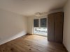 Der Raum hat einen Holzfußboden und ein Fenster. Es gibt keine Möbel. Tageslicht kommt durch das Fenster.