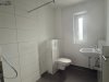 Der Raum zeigt eine Duschecke mit einer Toilette und einem Waschbecken in einem modernen Bad.