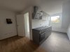 In dieser Wohnung befindet sich eine moderne Küche mit einem Fenster und einer Spüle.