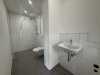 Ein kleines, modernes Badezimmer mit einer Dusche, einer Toilette und einem Waschbecken.