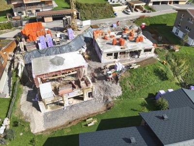 Bauarbeiten an mehreren Wohnhäusern in einer ruhigen Nachbarschaft. Baustelle bietet neuen Wohnraum mit Blick auf die Umgebung.