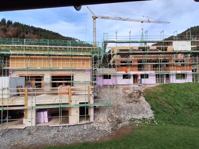 Baustelle zeigt den Fortschritt beim Bau eines modernen Wohnhauses in den Alpen während des Tages im Herbst.