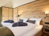 Schlafzimmer mit zwei Betten und Holzdekor In einem modernen Schlafzimmer stehen zwei Betten mit weißen Bettwäsche. Die Wände sind aus Holz.
