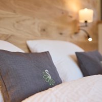 Gemütliches Schlafzimmer mit Kissen und Holz In einem Schlafzimmer liegen zwei Kissen auf einem Bett. Die Wände sind aus Holz und es gibt sanftes Licht.