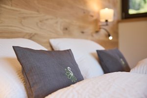 Gemütliches Schlafzimmer mit Kissen und Holz In einem Schlafzimmer liegen zwei Kissen auf einem Bett. Die Wände sind aus Holz und es gibt sanftes Licht.