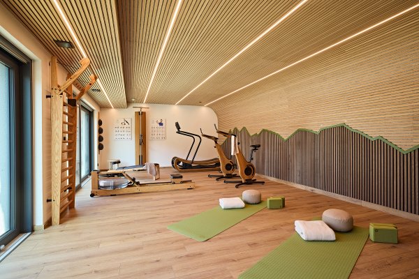 Der Fitnessbereich in den Siplinger Suites in Balderschwang Im Raum sind verschiedene Sportgeräte. Zwei Matten liegen bereit für Übungen. Es gibt auch Kissen und Blöcke.