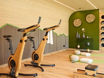 Der Raum zeigt zwei Trainingsgeräte in einem modernen Raum. Es gibt auch Matten und Dekoration an den Wänden.