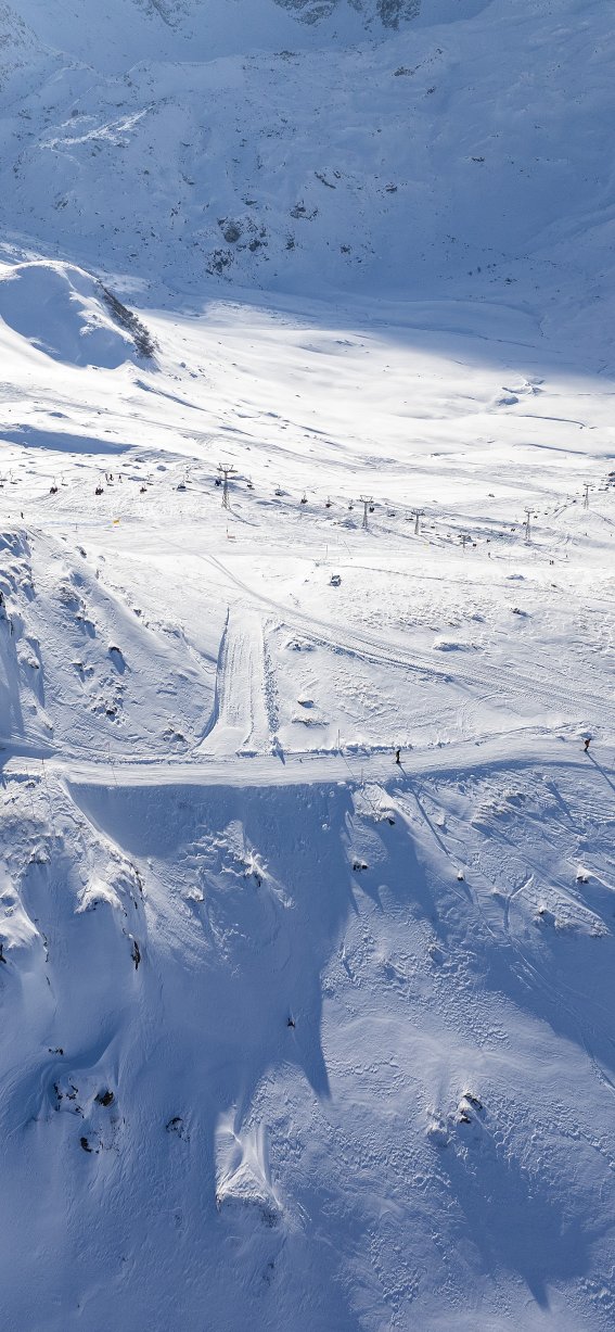 Skifahrer genießen die Pisten in einem sonnigen Skigebiet in den Alpen während des Winters.