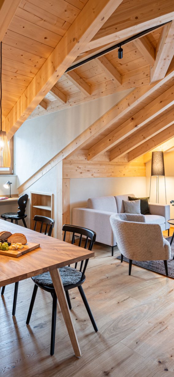 Gemütliche Ferienwohnung mit Holzinterieur, großem Fenster und Blick auf die Alpen, perfekt für einen ruhigen Urlaub.