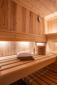 In der ruhigen Sauna genießen Menschen die entspannende Atmosphäre und die angenehme Wärme des Holzes.