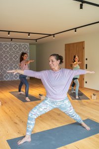 Eine Gruppe von Frauen macht Yoga-Übungen in einem ruhigen Raum. Sie konzentrieren sich auf die richtige Haltung und Atmung.
