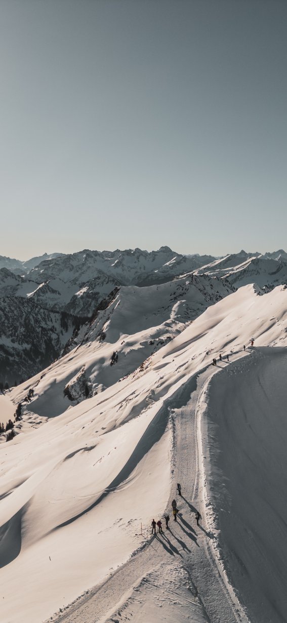 Eine atemberaubende Aussicht auf schneebedeckte Gipfel. Die Sonne scheint hell über die alpine Landschaft.