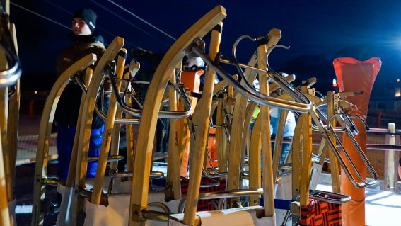 Skiausrüstung wird in der Dämmerung vorbereitet In der Dämmerung wird Skiausrüstung für den nächtlichen Einsatz am Berg organisiert. Sportler warten auf den Unterricht.