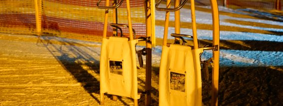 Zwei Holzschlitten stehen bereit, um in der Nacht auf gut präparierten Pisten zu fahren und Spaß zu haben.